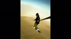 Daredevil surfs down dunes into clouds of sand in Chilean desert