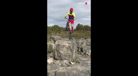 Title-winning BMX rider navigates over several feet high rocks all while riding his bike