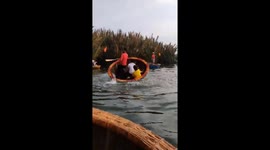 Tourists cling on as they're spun around on small basket boat by enthusiastic boatman