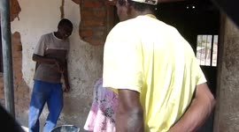 mujer de cape mclear atandose a su bebe a su espalda en Zambia