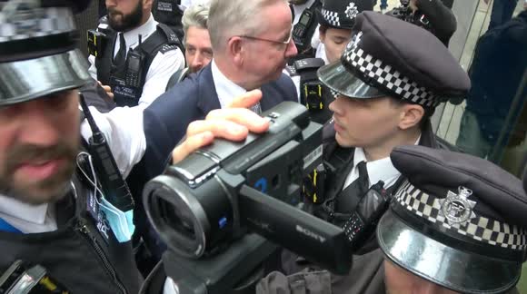 Michael Gove escorted by police after the MP is accosted by anti-vaccine protesters in London