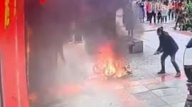 Brave passerby drags flaming scooter away from shop in southern China