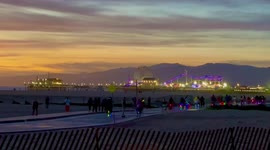 Hundred of bikes and scooters make their way to the Santa Monica Pier as the sunset dips into the Pacific Ocean.