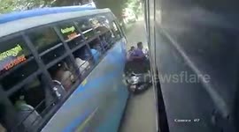 Two-wheeler borne family miraculously escape after being trapped between 2 busses in southern India