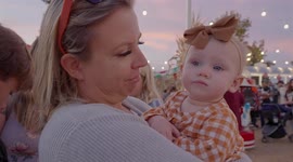 Young grandmother holding her only grandchild at a Halloween gathering