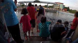 Experience what it’s like to walk through hundreds of fish in swollen river after rain in Thailand