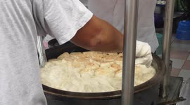 Food/Traditional pan-fried stuffed bun being cooked on the streets