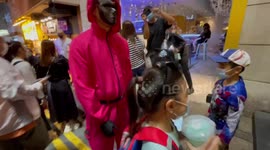 In Hong Kong children play trick or treat with “rock, scissor, paper” with Squid Game guards in Lan kwai Fong