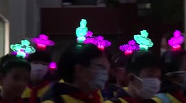 Chinese students wear luminous name tags on their heads to help parents locate them in the dark