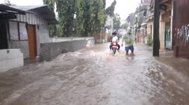 Residents forced to wade through submerged streets as downpours leave Jakarta flooded