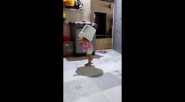 The three-year-old girl playfully put her head in the bucket