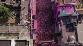 Celebration of Holy in India, Pushkar. People dancing on a colored main square. Aerial view