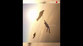 Just hanging out! Daredevil dangles by rope from wingsuit pilot in epic stunt