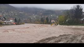 River in Bosnia bursts banks submerging excavator