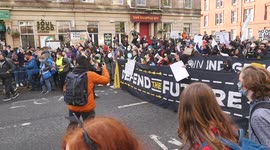 Climate Activists March Down A Road Holding Large Banner Glasgow COP26