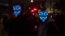 Protesters wearing Guy Fawkes masks approach Parliament Square on Bonfire Night