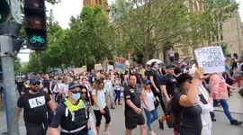 A crowd of thousands of protesters crosses the intersection, Melbourne, Australia