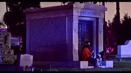 Halloween couple & a dog sitting by a crypt in the Hollywood Forever Graveyard