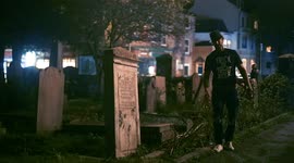 Guy in a graveyard on Halloween with a beer