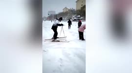 Residents ski to work on snow-covered roads after blizzard hits northern China