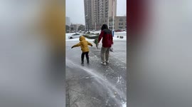 Winds blow strong enough to push father-son duo along road in northern China