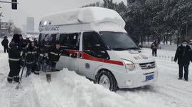 Firefighters free ambulance trapped in snow on Chinese road