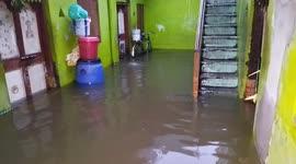 Residents in southern India wade through knee-high water as rain floods their homes
