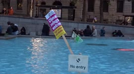 'Climate refugees welcome' placard spotted in Trafalgar Square fountain on the day of climate protests
