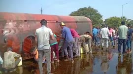 Locals fill their own containers from leaking oil tanker that overturned in central India