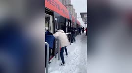 Commuters attempt to push struggling light rail carriage through snow-covered roads in China