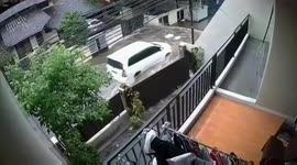 Wake of car driving through submerged street snaps residential fence in Indonesia