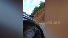 Landslide crashes onto road in front of cars after heavy rain in Indonesia