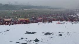 Hindu devotees perform rituals in river covered in chemical foam