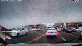 Snow sliding down car roof blocks motorist's view after braking in northern China