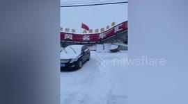 Car shop crushed by collapsed store sign during blizzard in China