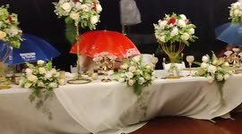 Determined guests eat under umbrellas as rainstorm batters wedding reception
