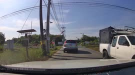 Impatient driver smashes through level-crossing barrier in Thailand