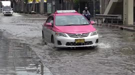 Cars drive through flooded road during rainy season in Bangkok, Thailand