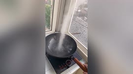 Tornado-shaped smoke rises up when woman heats up cooking oil in China