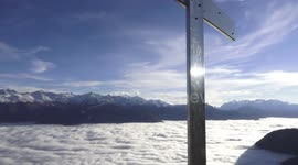 Dense stratus lowlevel clouds at the bottom of swiss alpine valley while great Sun shines above