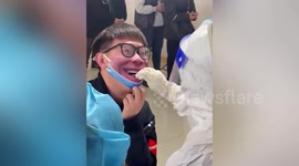 Chinese student wears hilarious mask to entertain paramedics during COVID-19 test