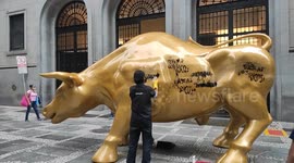 Cleaners unable to remove graffiti on golden bull just installed in Brazil's Sao Paulo