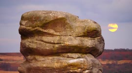 Spectacular orange full Beaver moon rises over Eagle Stone in UK's Peak District