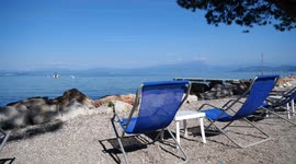 deck relax chairs in front of garda lake in italy in summer
