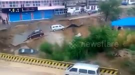 Vehicles washed away as road collapses into river in China