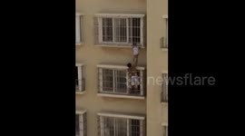Neighbour rescues toddler dangling from balcony