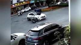 Motorcyclist rolls over and lands on feet after crashing into car in eastern China