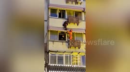 Firefighters rescue elderly man hanging from third-floor window of building in eastern China