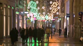 People walking on the main shopping street of Amsterdam, Holland at night was th colorful decorations.