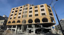 Palestinian workers remove the rubbles of al-Jawhara tower which was hit by Israeli strikes during the recent 11-day conflict between Israel and Hamas on May